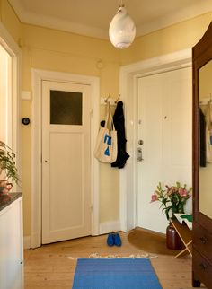 a hallway with a blue rug and white door