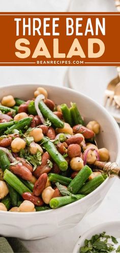 three bean salad in a white bowl with green beans, onions and parsley on the side