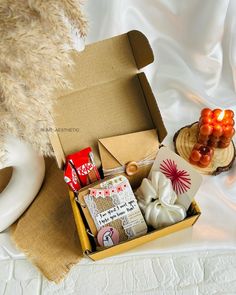 a box filled with candy and candies on top of a white table cloth next to a teddy bear