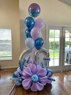 a balloon centerpiece with flowers and balloons in the shape of the number 50 on it