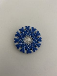 a small blue and white pinwheel sitting on top of a table next to a wall