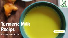 a bowl filled with yellow liquid next to some vegetables