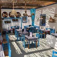 an outdoor dining area with blue and white tablecloths