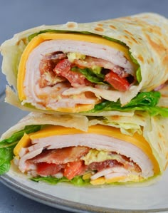 two burritos with meat, cheese and lettuce are stacked on top of each other