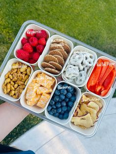 a person holding a tray filled with different types of snacks