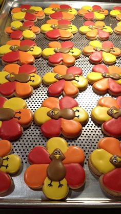 decorated cookies in the shape of turkeys on a baking sheet