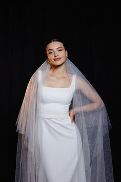 a woman wearing a white wedding dress with a long veil on top of her head