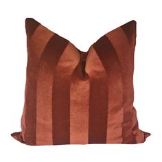 an orange and brown striped pillow on a white background