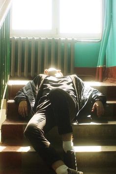 a man laying down on some stairs with his head in the air and eyes closed