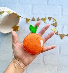 a hand is holding an orange shaped object