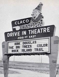 an old sign advertising the movie drive in theatre with clowns on it's head