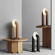 three wooden tables with lamps on them in front of a mirror and another table next to it