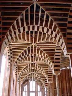 the inside of a large building with wooden beams and arches on it's sides