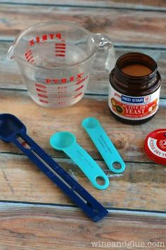 the ingredients to make an ice cream dessert are displayed on a wooden table with spoons and measuring cups