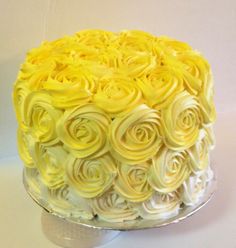 a yellow cake with white frosting roses on it