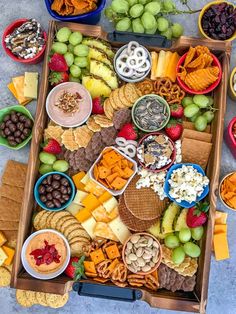 an assortment of cheeses, crackers, fruit and snacks