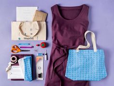 an assortment of crafting supplies laid out on a purple surface