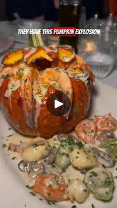 a white plate topped with a pumpkin covered in shrimp