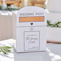 the wedding post box has been decorated with an orange ribbon and is sitting on top of a table