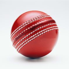 a red leather cricket ball with white stitching