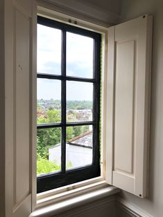 an open window in a white wall with black trim and windowsills on both sides