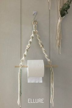 a toilet paper roll hanging from a rope on a wall