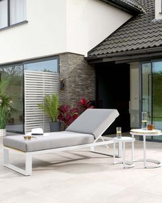 a lounge chair sitting on top of a patio next to a table