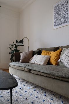 a living room with a couch, table and rug on the floor in front of it