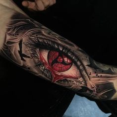 an eye tattoo on the arm with red and black ink, which looks like it has been