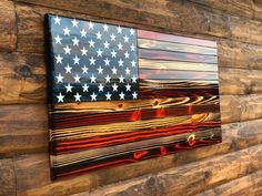 an american flag is hanging on the side of a wooden wall