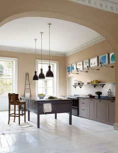 an archway in the kitchen leads to a breakfast nook and dining room with two bar stools