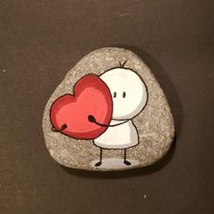 a rock with a cartoon character holding a heart