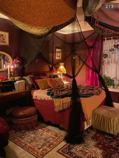 a canopy bed in the middle of a room with pink curtains and rugs on the floor