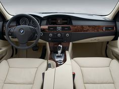 the interior of a car with beige leather seats and steering wheel, including center console