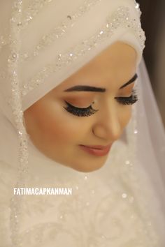 a close up of a woman wearing a wedding dress and veil with glittered eyeshades