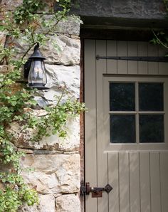 a light that is on the side of a stone building next to a door and window