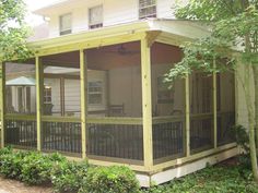 a screened porch in front of a white house