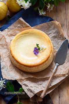 there is a pie with flowers on it and a spoon next to some lemons