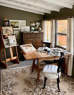 a room with green walls and wooden furniture in the corner, along with paintings on the wall