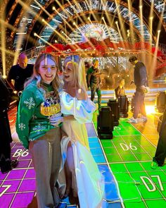 two women standing next to each other at a carnival