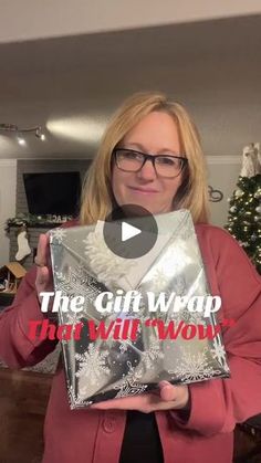 a woman holding up a silver envelope with the words, the gift wrap that will work