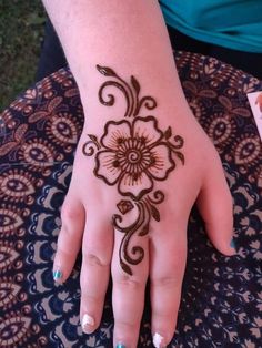 a woman's hand with henna tattoos on it