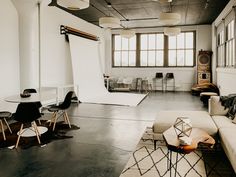 a living room filled with lots of furniture next to a white table and chair in front of a window