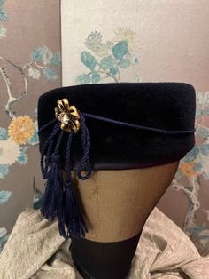 "1960 vintage, \"Linda Farrell\" pillbox hat, stamped, 'Genuine Velour, Imported Fur. Deep, navy blue color with a cord wrapped around ending on the right side with the two tassels secured by a, two toned, brass flower with a, large, rhinestone center. There is a 2 inch ,navy satin band around the inset into the edge of the hat. 22\", 4\" high" Modern Pillbox Hat, Royal Pillbox Hat, Navy Pillbox Hat, Black Pillbox Hat, 30s Pillbox Hat, Cord Wrap, Pillbox Hat, Pill Boxes, Navy Blue Color