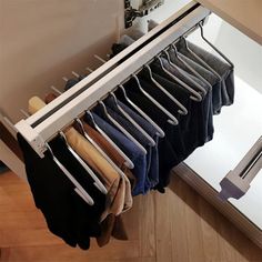 a rack with clothes hanging on it in front of a mirror