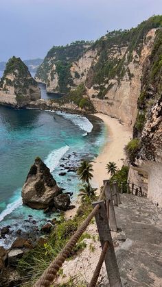 stairs leading down to the beach and ocean from an overlook point on top of a cliff