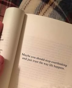 a person holding an open book in their hand with the words maybe you should stop over thinking and just trust the way life happens