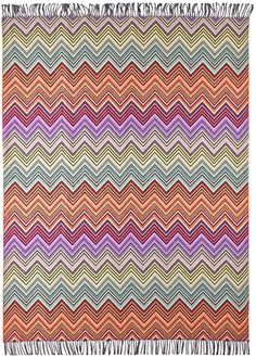 a multicolored rug with fringes on it and an area rug in the shape of a zigzag pattern