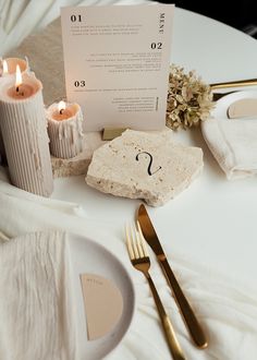 the table is set with candles and place cards