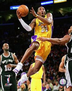 a basketball player jumping up to dunk the ball in front of two other players